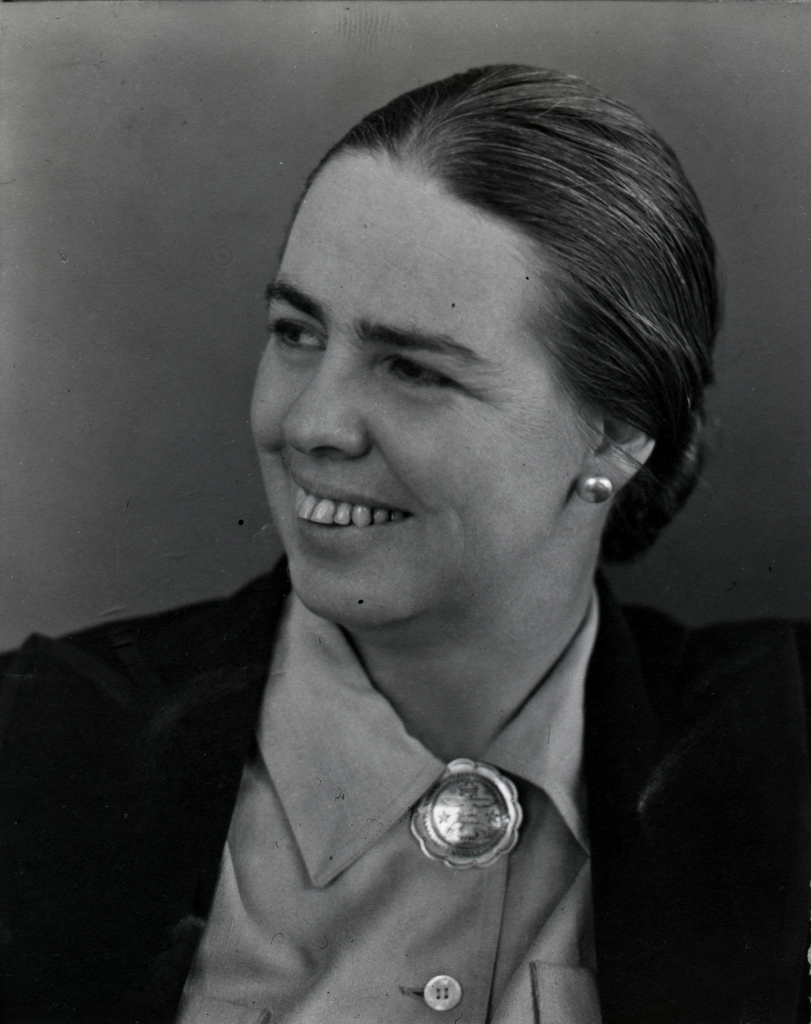 Black and white portrait of a Caucasian women with brown hair wearing a bun