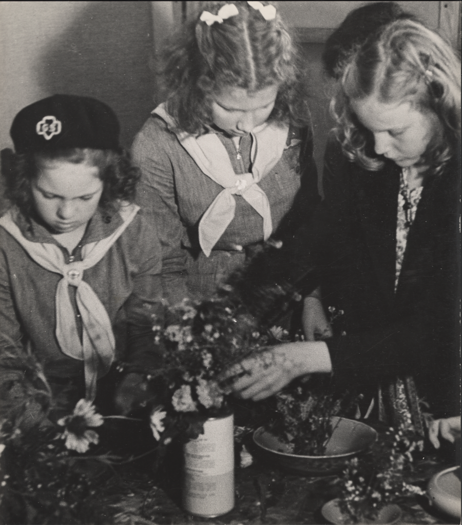 A black and white photograph of a group of young girls doing an art project