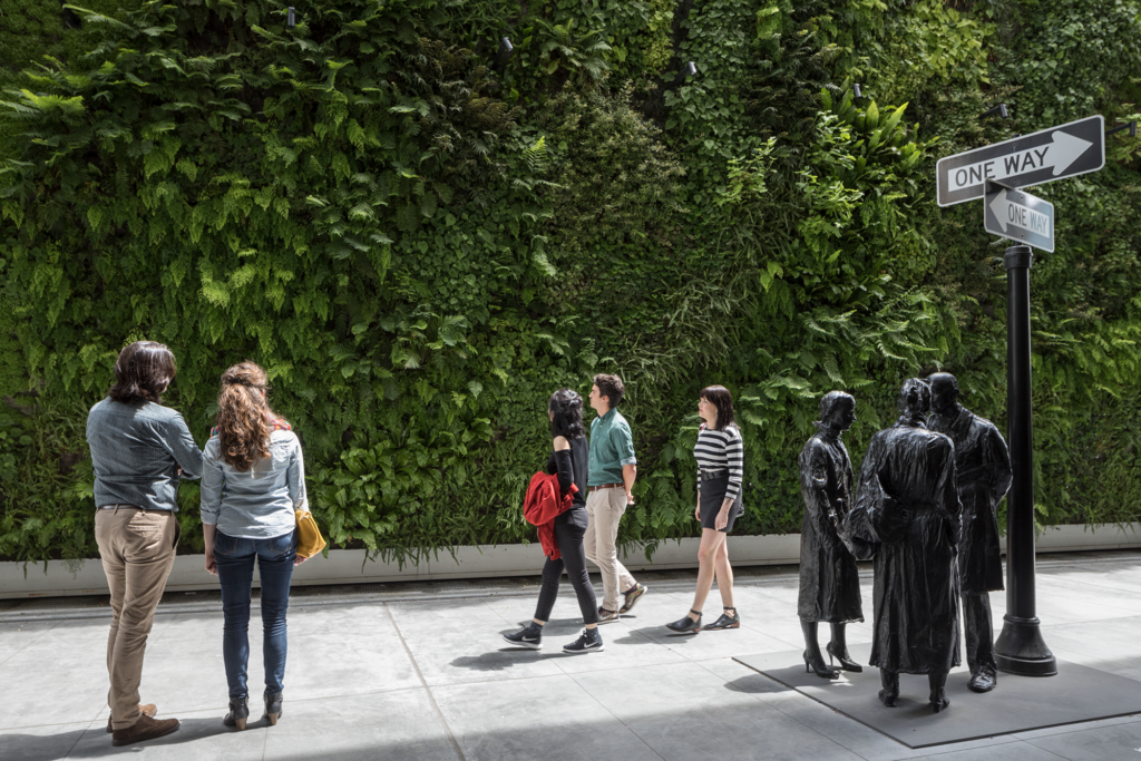 Visitors walking past the living wall